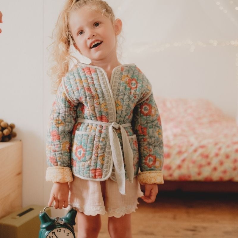 Lachendes Mädchen in Louise Misha Jacket Teliani | Mädchen Jacke von hinten