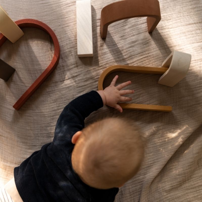 Spielendes Baby mit MinMin Copenhagen Mini Rainbow | Kinder Holzspielzeug pastel